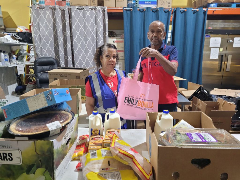 two volunteers packing food boxes for a constituent in need