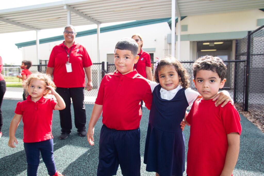 Four pre-school age children smile for a photo at a Orange County Head Start location.