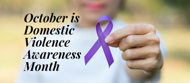 October is Domestic Violence Awareness Month picture of a hand holding a purple ribbon.