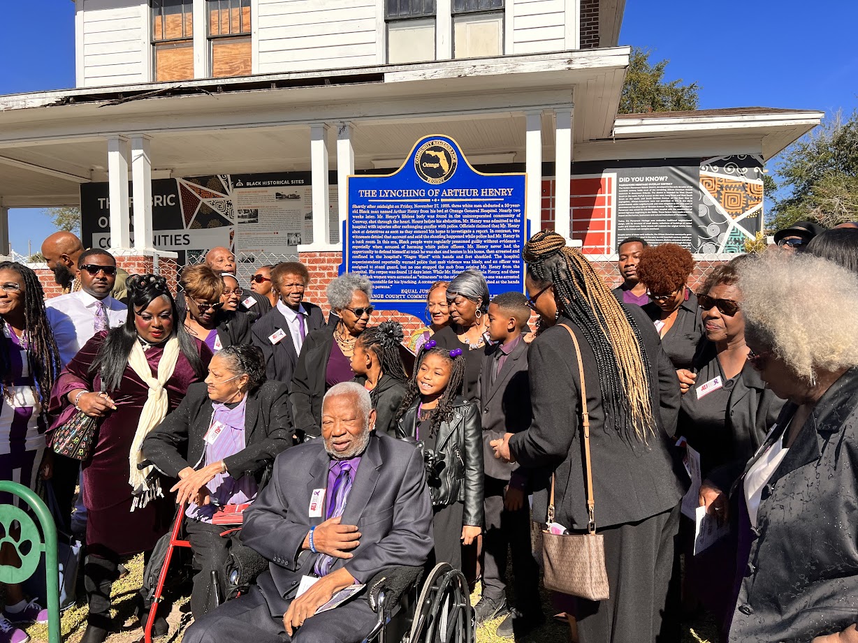 Arthur Henry's family poses for photo in front of memorial marker.