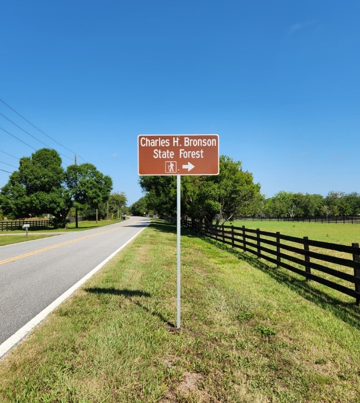 This photograph shows the new sign pointing to the entrance to Charles H. Bronson State Forest