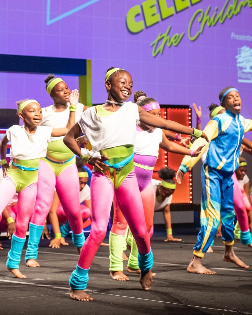 This photograph shows members of the Boys and Girls Club performing in 1980's themed clothing