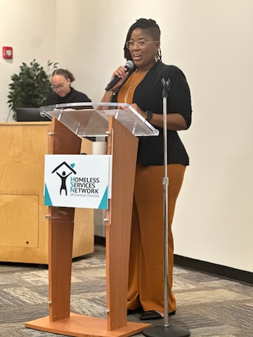 photograph of a woman speaking at the Brighter Days Initiative event