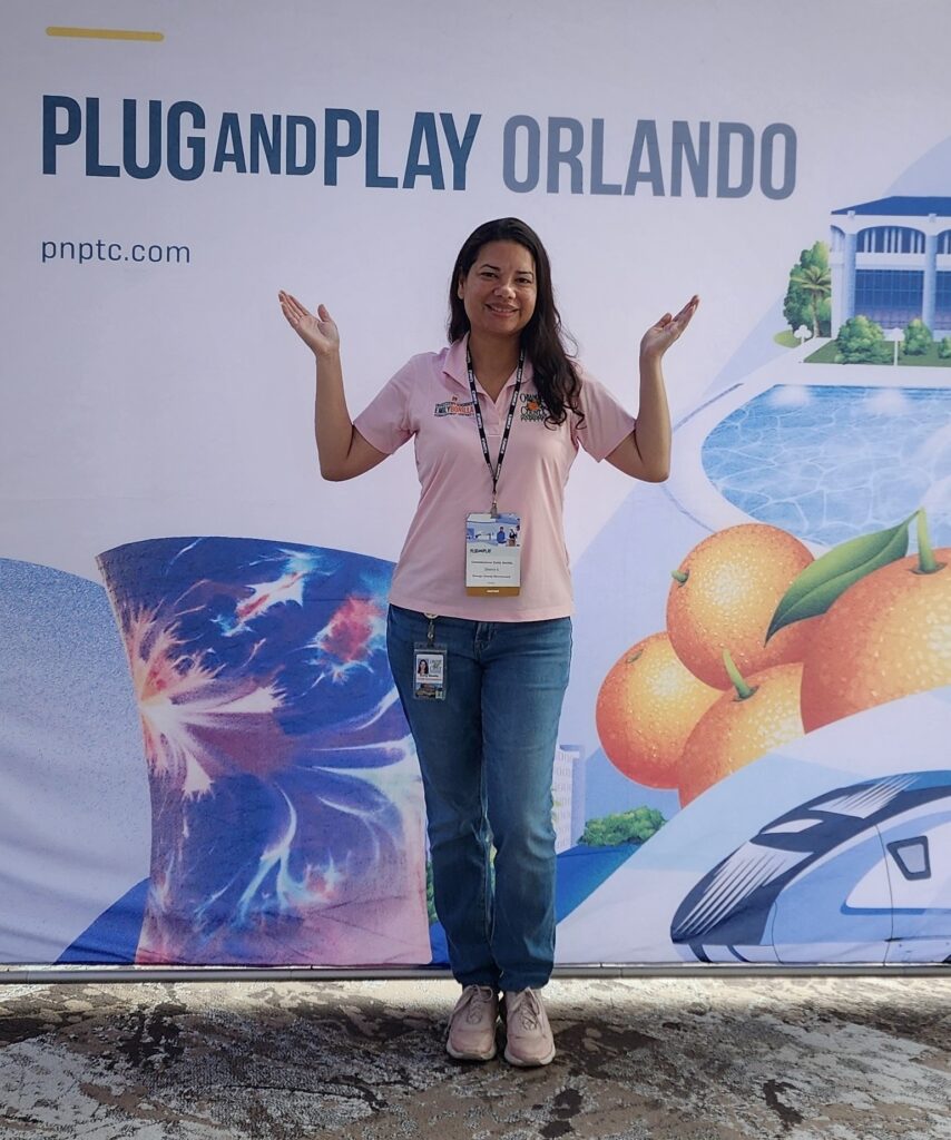 photograph of commissioner Bonilla in front of the plug and play orlando sign