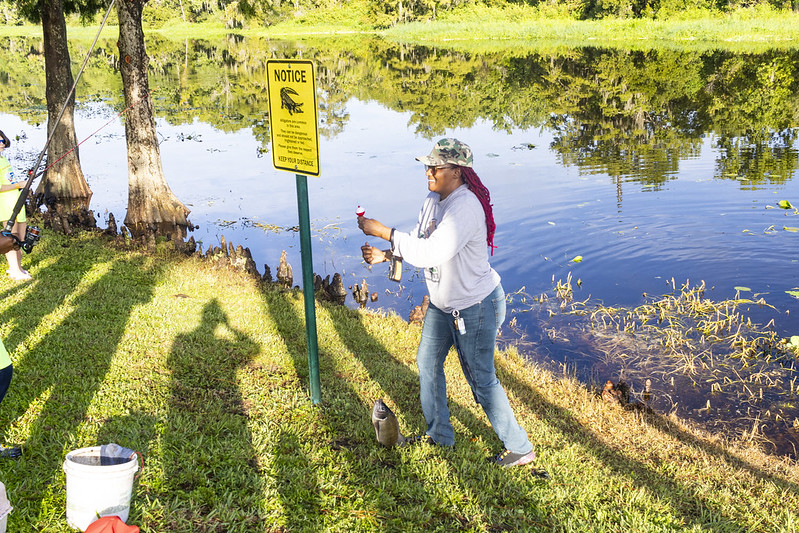 photograph of a woman with a fish on her line