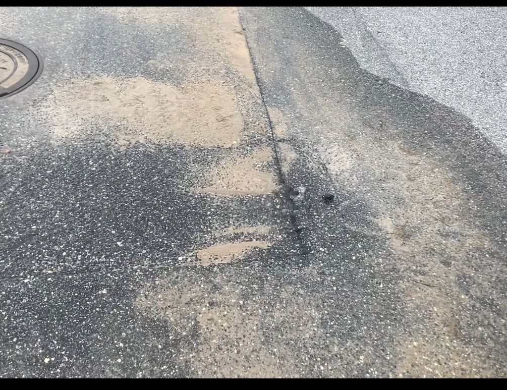 photograph of water leaking from a street